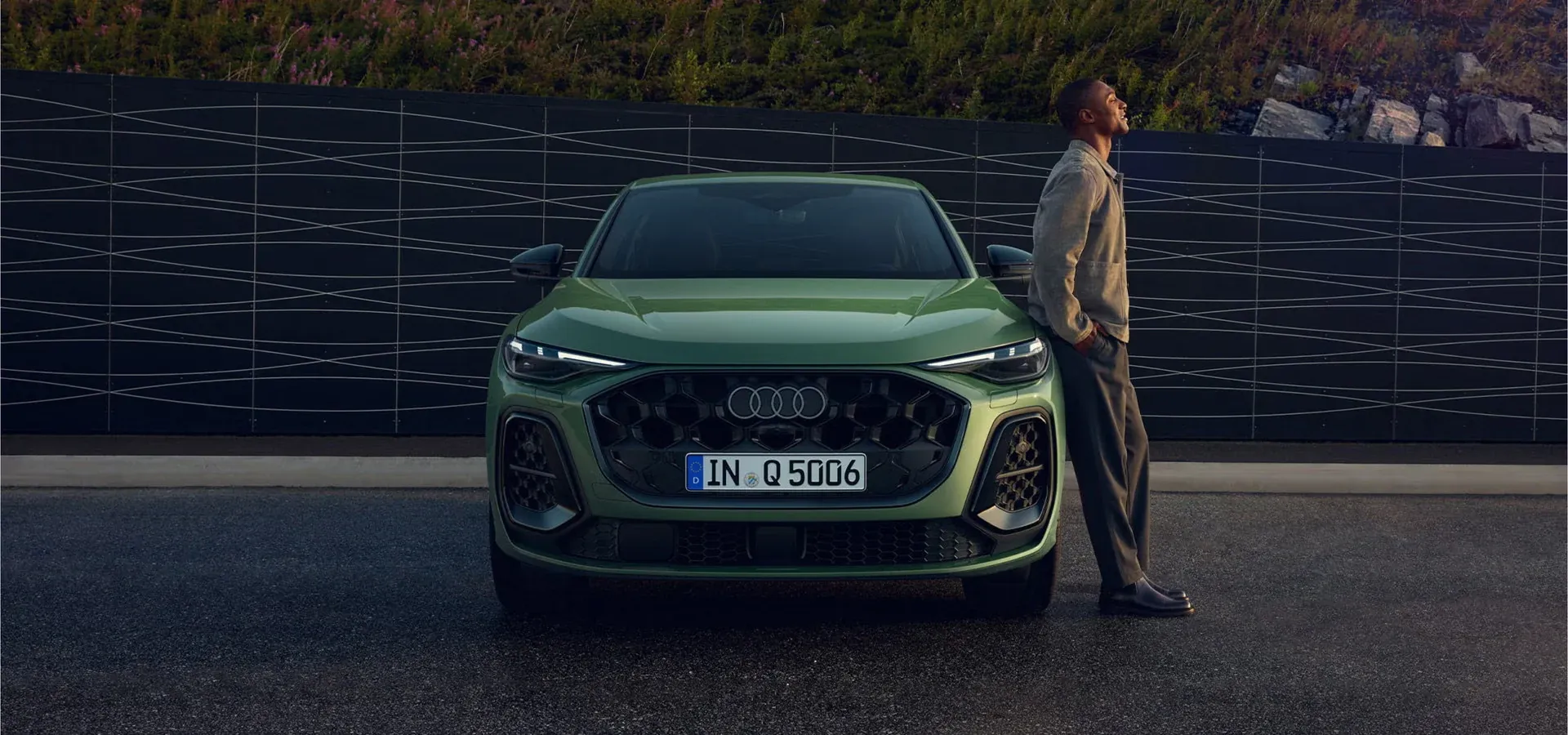 Audi Q5 junto a una persona en la ciudad